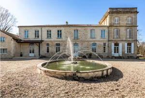a water fountain in front of a large building at Château Féger 5 suites in Camblanes-et-Meynac