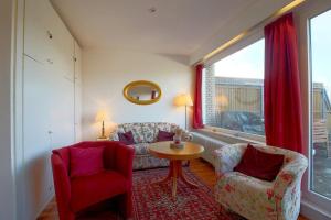 een woonkamer met twee stoelen, een tafel en een raam bij Apartment 631 in Hohegeiß