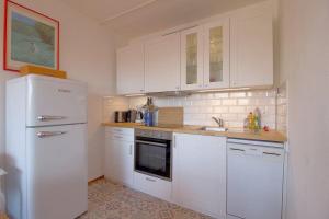 een keuken met witte kasten en een witte koelkast bij Apartment 631 in Hohegeiß