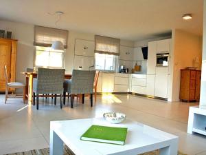 a living room with a table and a kitchen at Sterntaucher in Klein Gelm