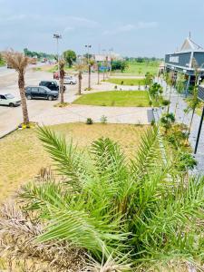 a park with palm trees and a parking lot at Randhir Hotel & Restaurant 