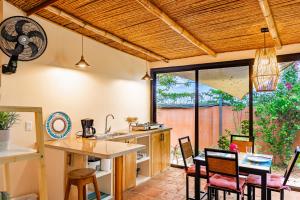 a kitchen with wooden ceilings and a table and chairs at Casa Mapache Pool and Breakfast Available near Tamarindo Beach in Tamarindo