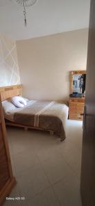 a bedroom with a bed and a dresser at Golf msnana in Tangier +4 photos