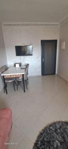 a living room with a table and chairs and a couch at Golf msnana in Tangier