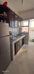 a kitchen with a white refrigerator and a stove at Golf msnana in Tangier