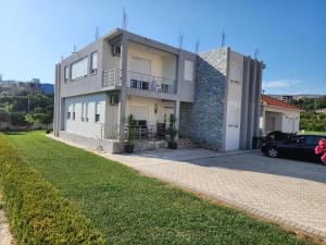 a house with a car parked in front of it at Gjoni Apartments in Ulcinj