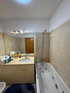 a bathroom with a sink and a tub and a toilet at City World Apartment in Maia