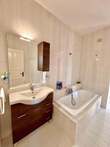 a bathroom with a sink and a bath tub at Villa Katerina in Capo Vaticano