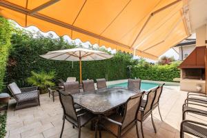 Un patio con una mesa y sillas y una sombrilla. en Bavaria, en Palazzo Vianello