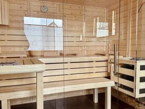 KrumminFerienhäuser Ankerplatz 1 und 2 Usedom mit Sauna, Kamin und Garten的一间设有木墙、长凳和窗户的桑拿浴室