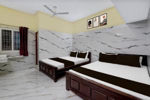 RanipetHotel O RR Residency的配有两张大理石墙的床铺
