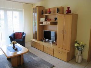 a living room with a entertainment center with a flat screen tv at Ferienwohnung Promenadenweg Nesselwang 10-2 in Nesselwang