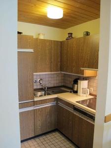 a kitchen with wooden cabinets and a sink at Ferienwohnung Promenadenweg Nesselwang 10-2 in Nesselwang