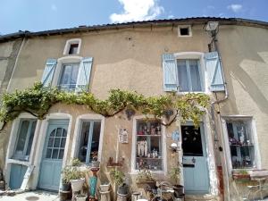 an old building with blue doors and plants at Le Gîte du Lapin Bleu in Baigneux-les-Juifs