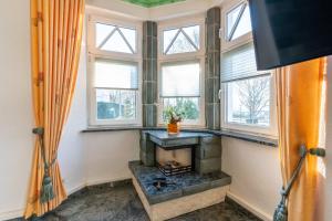 a living room with a fireplace and windows at Villa Venske 3-Raum Fewo, Balkon, Parkplatz in Binz