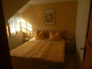 een slaapkamer met een bed met twee kussens erop bij Ferienwohnung "Achtern Diek" 45324 in Groß Zicker