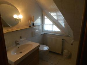 een badkamer met een wastafel en een toilet en een raam bij Ferienwohnung "Achtern Diek" 45324 in Groß Zicker +4 foto's