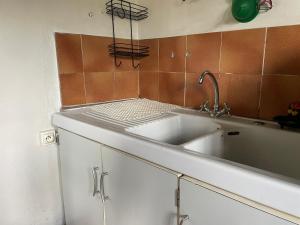 a kitchen with a white sink and brown tiles at l'atelier in Saint-Martin-des-Champs +35 photos