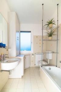 a white bathroom with a tub and a sink at Graziosa in Isola Albarella