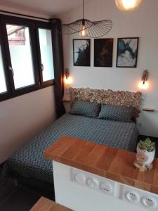 a small bedroom with a bed and a table at Micro Maison indépendante in Commelle-Vernay