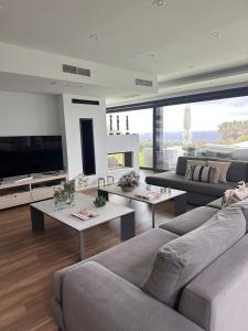 a living room with couches and tables and a tv at Villa Essencia in Zahara de los Atunes