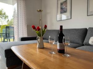 een fles wijn en twee glazen op een tafel bij Ferienwohnung Heidelbeere in Graal-Müritz