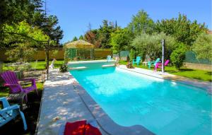a swimming pool in a yard with colorful chairs at Stunning Home In Montélimar in Montélimar