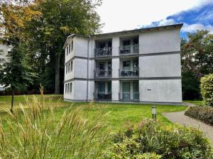 a white building with balconies in a yard at Haus am Buchenpark 02 in Neuhof