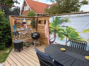 a patio with a table and chairs on a deck at Happy Mermaid Garden Cabin in Aalborg