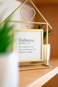 a gold frame with a heart sign on a table at Ferienwohnung Sonnenbichl in Schattwald +9 photos