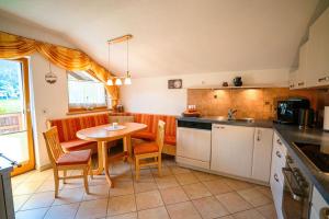 a kitchen with a table and a table and chairs at Ferienwohnung Sonnenbichl in Schattwald