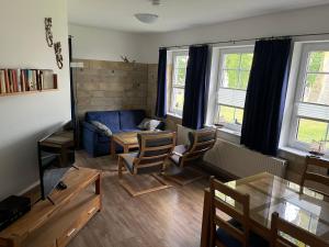 a living room with a blue couch and a table at Haus am Buchenpark 02 in Neuhof