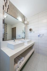 a bathroom with two sinks and a large mirror at Sea View Village in Vasilikos