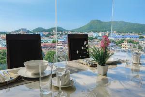 a dining table with a view of a city at The Sriracha Residence in Si Racha