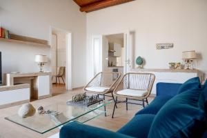 a living room with a blue couch and chairs at Casa di charme "Al Moro Avola " in Avola