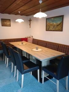 a dining room with a wooden table and chairs at Haus Deule in Sankt Gallenkirch