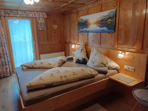 a room with a bed in a wooden cabin at Haus Deule in Sankt Gallenkirch