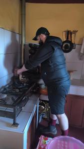a man standing in front of a stove in a kitchen at Luquina 360 in Puno