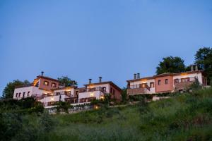 Una fila de casas en una colina al anochecer en Lions Nine, en Mouresi