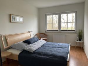 a bedroom with a bed and a window at Landhaus zum Strande - 44-08 in Kägsdorf