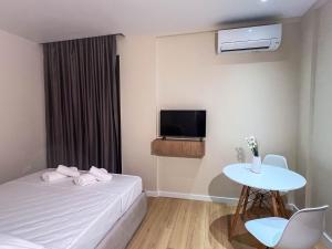 a room with a bed and a table and a tv at Serenita Hotel in Vlorë