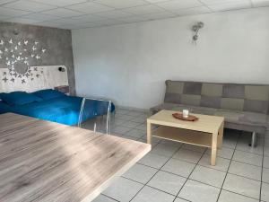una sala de estar con un sofá y una mesa en La Petite Baratte, en Beure