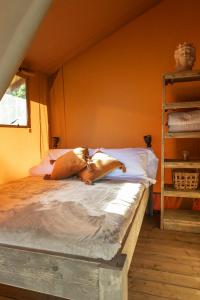 a bed with two pillows on it in a room at Etna Glamping in Milo