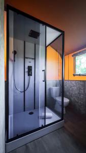 a bathroom with a glass shower with a toilet at Etna Glamping in Milo +15 photos