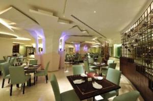 un comedor con mesas, sillas y luces púrpuras en The Nala suite ming garden kota kinabalu, en Kota Kinabalu