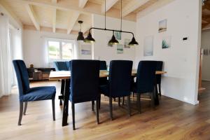 a dining room with a wooden table and blue chairs at Kugelberg 13 in Heiligenhafen