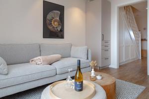 a living room with a couch and a table with a bottle of wine at Ferienwohnung Strandloft in Wenningstedt in Wenningstedt