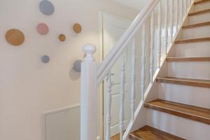 a staircase with white railings and wood floors at Ferienwohnung Strandloft in Wenningstedt in Wenningstedt +11 photos