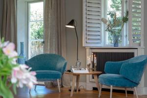 a room with two chairs and a table and a lamp at Kampenherz - Traumhaftes Einzelhaus im Herzen von Kampen in Kampen