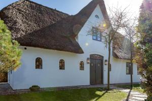 a white house with a thatched roof at Kampenherz - Traumhaftes Einzelhaus im Herzen von Kampen in Kampen